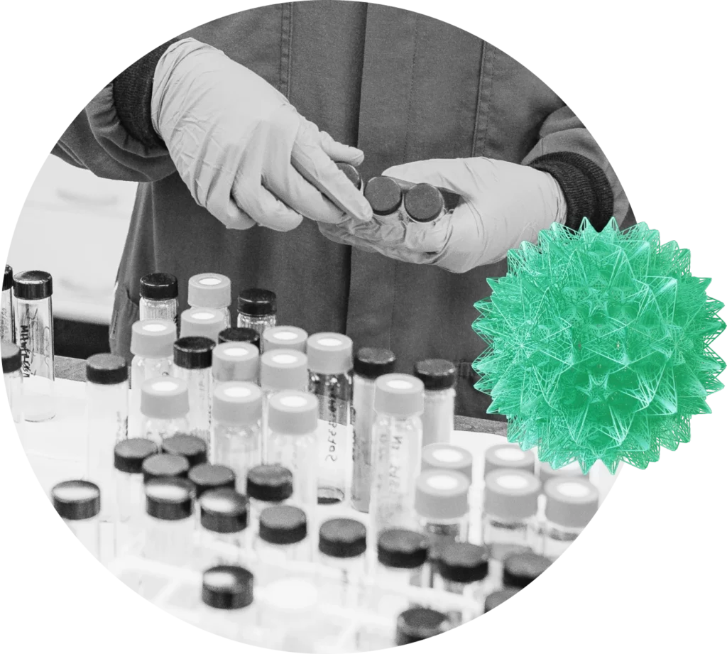 Gloved hands hold a few glass vials in a lab