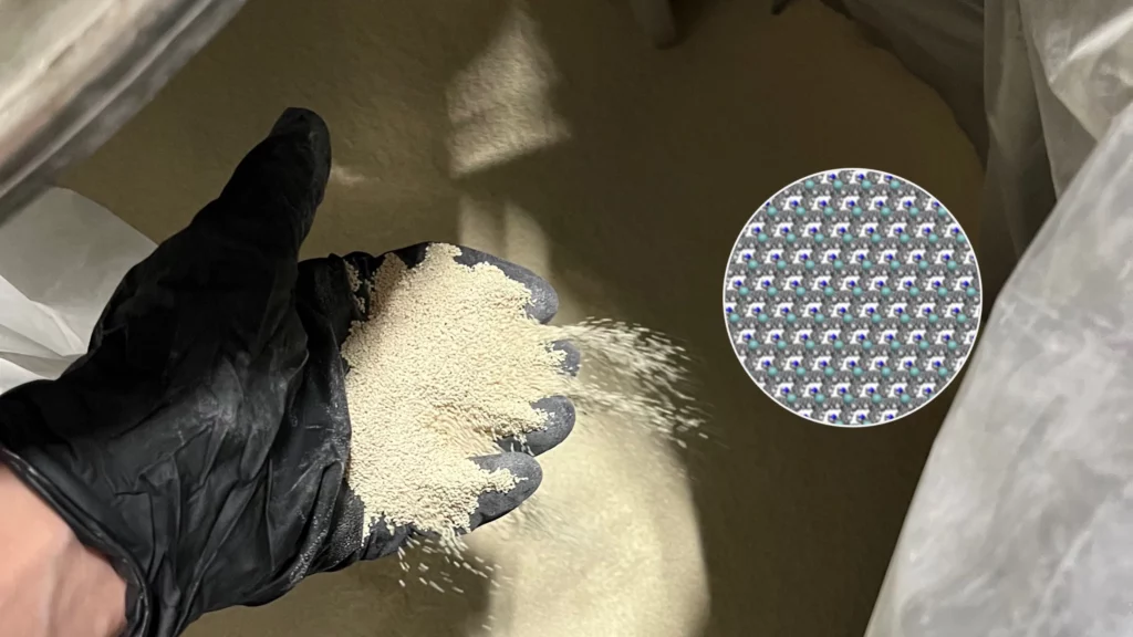 A scientist holds fine crystalline MOF powder in a gloved hand; an inset shows a magnified lattice structure revealing the MOF material’s intricate design.